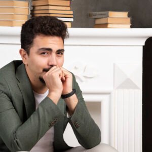 A man smiling politely at work while looking tired and sad in his eyes, reflecting the hidden struggle of high-functioning depression.